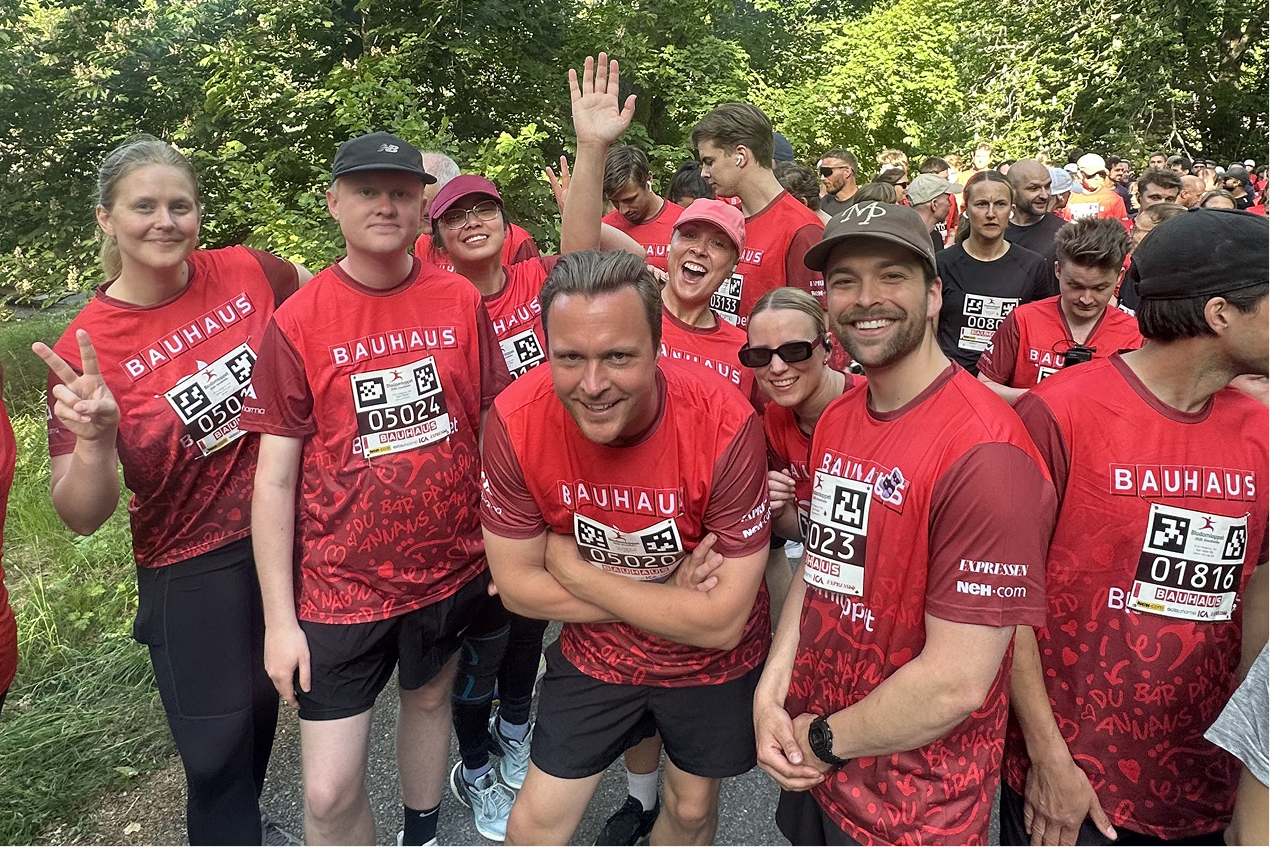 En grupp kollegor från qte poserar i röda tröjor innan Blodomloppet.