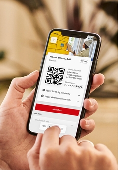 En person håller en mobil i handen och använder DHL Freights app.